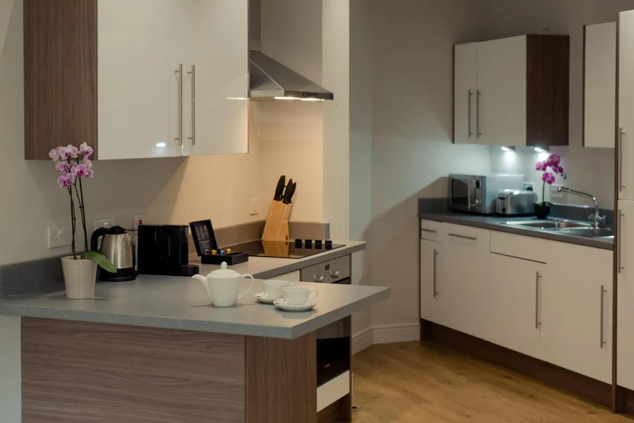 Apartment kitchen with white cabinets and worktop at Bath Street, Glasgow